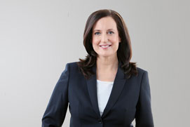 Bewerbungsfotos Hilden. Dynamisches Bewerbungsfoto von  einer Frau  freigestellt vor grauem Hintergrund.