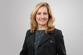 Bewerbungs-Fotos Hilden. Entspanntes Bewerbungsfoto von einer Frau freigestellt vor grauem Hintergrund.