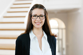Authentisches Businessfoto von einer Frau im Büro in Dortmund mit einer Treppe im Hintergrund.