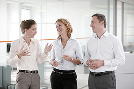 Lockere Besprechung im Gang. Businessfoto für drei Unternehmensberater aus Köln.