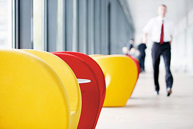 Eine Alltagssituation mit einem gehenden Mitarbeiter. Die farbigen Möbel unterstreichen die moderne Attitüde des Unternehmens aus Düsseldorf.
Das Businessfoto fängt diese ein.