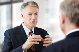 Business Coach bei der Arbeit im Gespräch. Ein glaubwürdig anmutendes Businessfoto zum Aufbau von Vertrauen für einen Coach aus Düsseldorf.