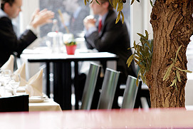 Restaurant Atmosphäre festgehalten in einem Foto mit zwei Personen am Tisch beim Gespräch und einem Glas Wein. Besondere Restaurant Fotos vom Fotograf in Köln.