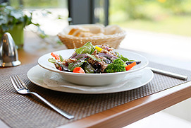Ein Salatteller auf einem Tisch in der hellen Atmosphäre eines Essener Hotel Restaurants. Schöne professionelle Food Fotos in Essen.