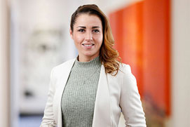 Mitarbeiterfotos Dortmund. Mitarbeiterfoto von einer Frau vor unscharfem Büro Hintergrund für ein Unternehmen.