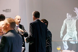 Einducksvolle Szene bei einem Business Event in Frankfurt. Drei Personen unterhalten sich während im Hintergrund eine Kunstprojektion
abläuft. Künstlerische Eventfotos in Frankfurt.