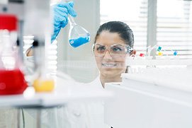 Ein Foto von einem Labor in Frankfurt, Frau mit Glaskolben. Besondere Laborfotos und Industriefotos vom Profi Fotografen für Frankfurt.