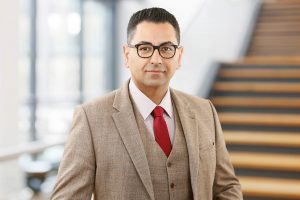 Business Portrait Köln, Düsseldorf, Bonn, Leverkusen, Essen. Unternehmer lächelnd vor Business Hintergrund.