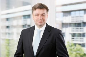 Business Portrait Köln, Düsseldorf, Bonn, Leverkusen, Essen. Geschäftsführer lächelnd vor Business Hintergrund.