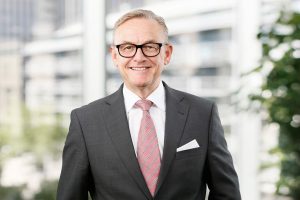 Business Portrait Köln, Düsseldorf, Bonn, Leverkusen, Essen. Geschäftsführer lächelnd vor Business Hintergrund.