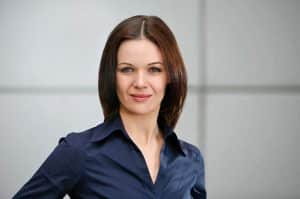 Business Portrait Köln,, Bonn, Leverkusen, Essen. Frau lächelnd vor Business Hintergrund.