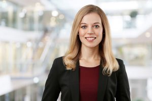 Business Portrait Köln, Düsseldorf, Bonn, Leverkusen, Essen. Frau lächelnd vor Business Hintergrund.