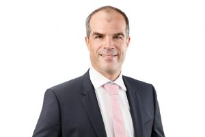 Mitarbeiterfoto, Mitarbeiterportrait Mann, lächelnd, vor neutralem Hintergrund, Köln, Bonn, Düsseldorf, Essen, Leverkusen, NRW