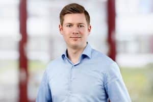 Mitarbeiterportrait Mann, lächelnd, vor Business Hintergrund, Köln, Bonn, Düsseldorf, Essen, Leverkusen, NRW, Aachen.