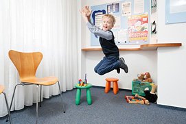 Ein Kind beim Spielen im Wartezimmer in einer lLeverkusener Zahnarztpraxis. Besondere Praxosfotos in entspannter Atmosphäre
in Leverkusen.